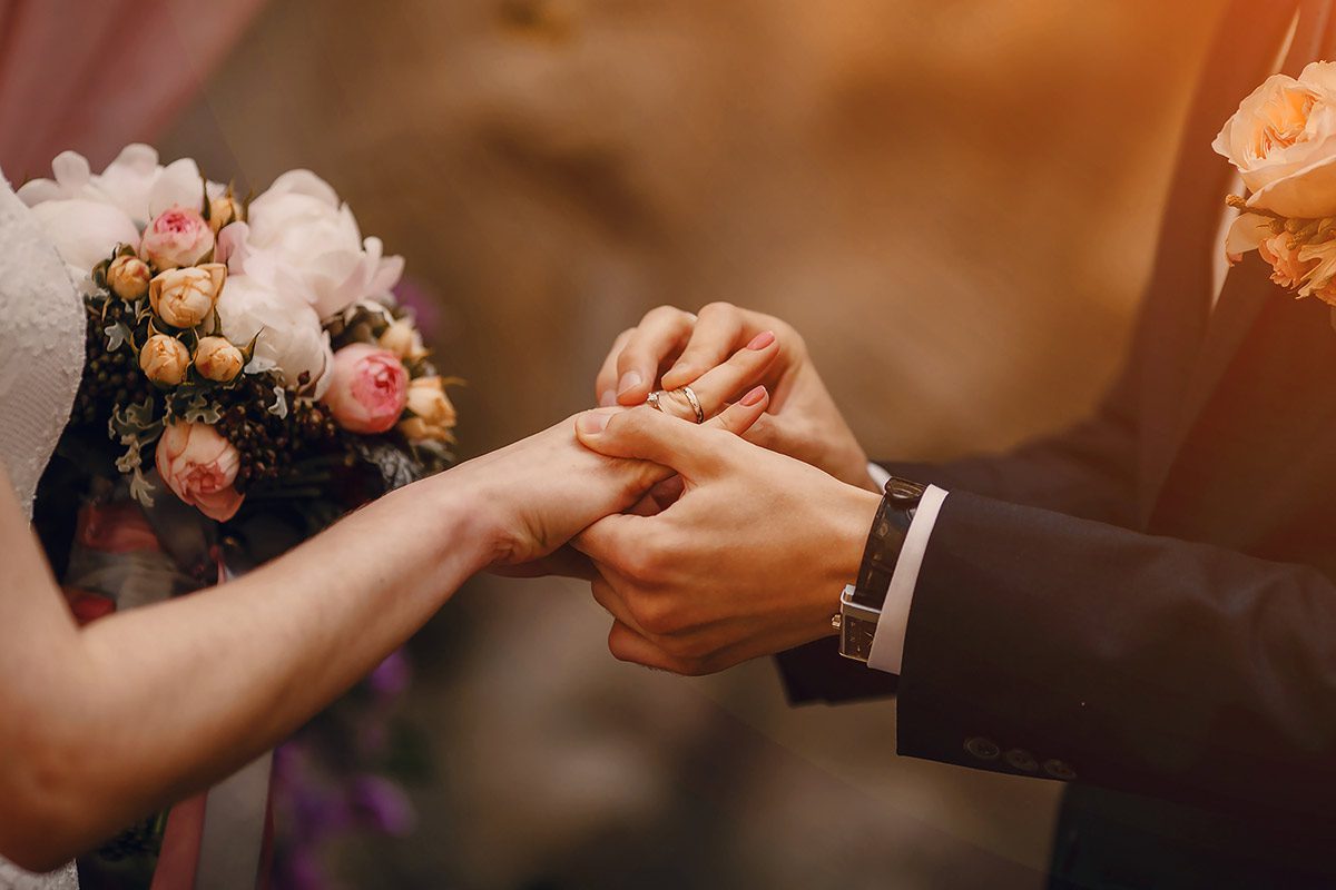 The Corbet Arms is one of the most loved unique wedding venues in Shropshire. The image depicts a ring exchange at a wedding ceremony.